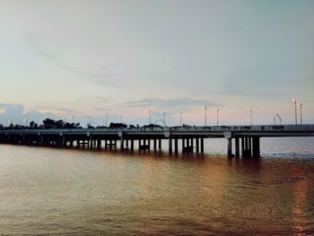 Pier over sea against sky during sunset