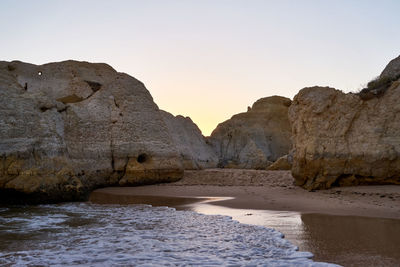 Rock formations in water against clear sky
