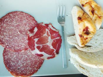 Top view of bacon with bread and fork on plate