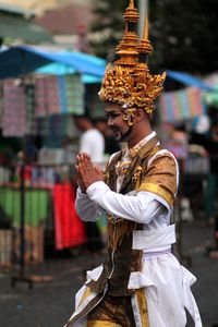 Side view of young man in traditional clothing standing on road