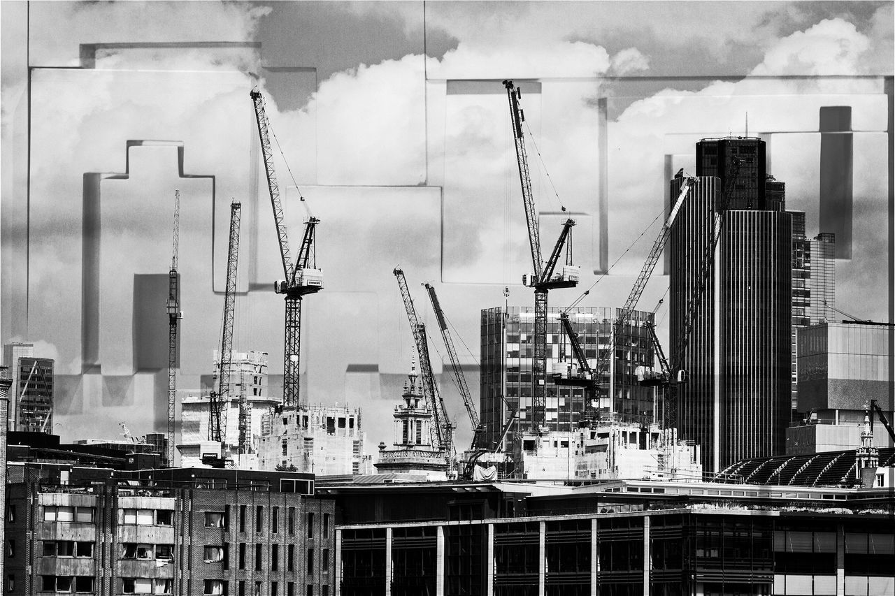 CRANES AGAINST SKY IN CITY