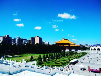 View of park in city against blue sky
