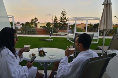 People sitting on table at restaurant against sky