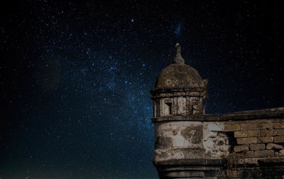 Low angle view of clock tower against sky at night