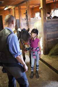 Girl with horse in stable