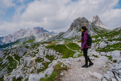 Woman standing on rock against mountains