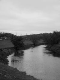 Scenic view of river against cloudy sky