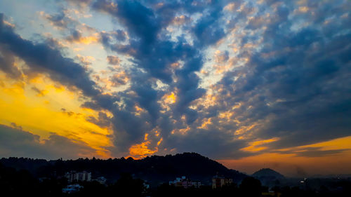 Silhouette buildings against sky during sunset