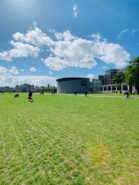 People playing on field against sky