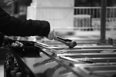 Cropped hands of man serving food at market stall