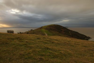 Scenic view of landscape by sea against sky