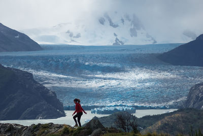 Man standing on snowcapped mountain against sky