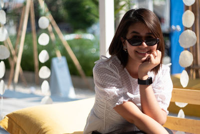 Young woman looking away while sitting outdoors