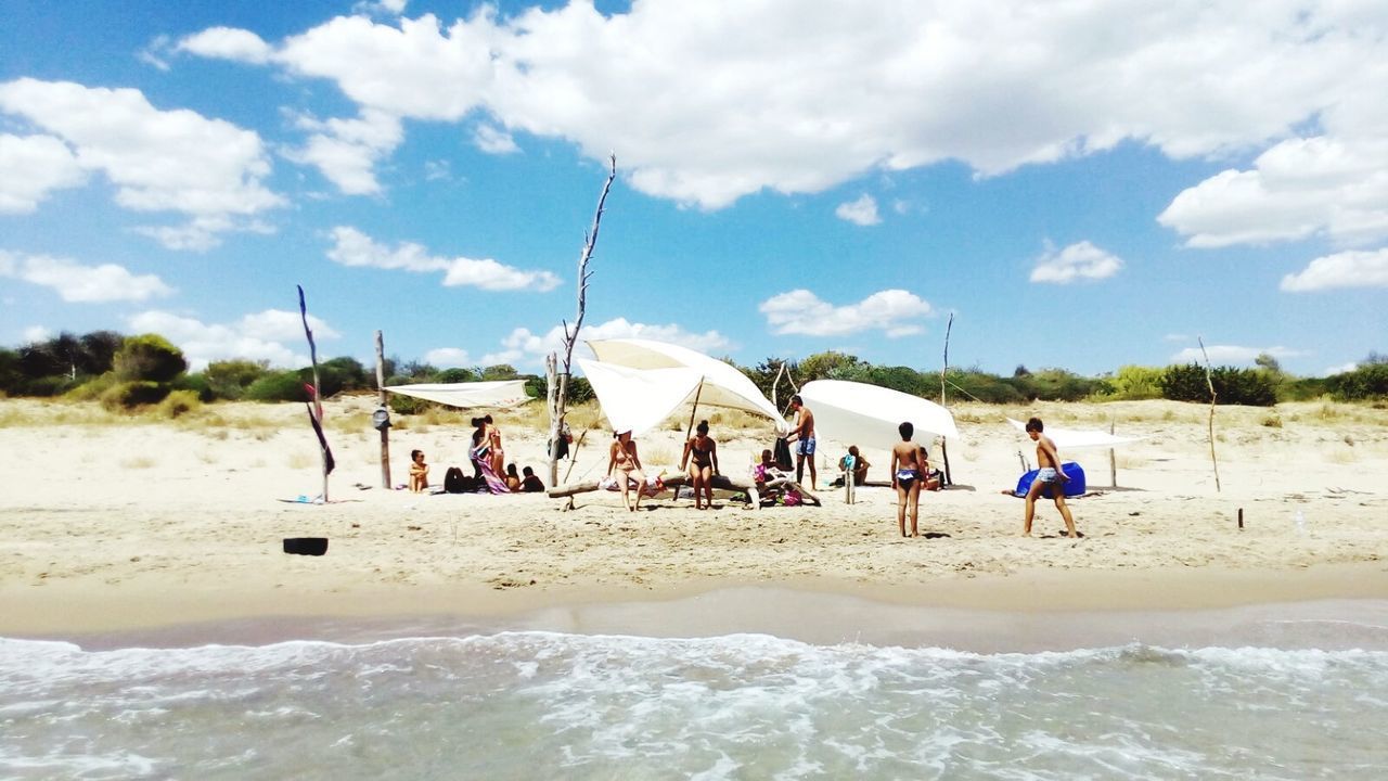 PEOPLE ON BEACH AGAINST SKY