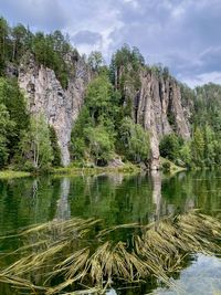 Scenic view of lake by trees against sky