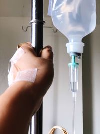 Cropped hand of woman wearing iv drip in hospital