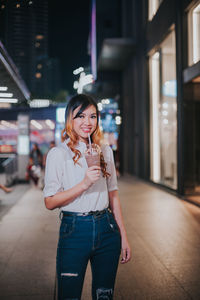 Portrait of smiling woman standing in city