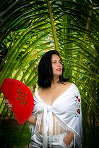 Portrait of young woman with palm tree