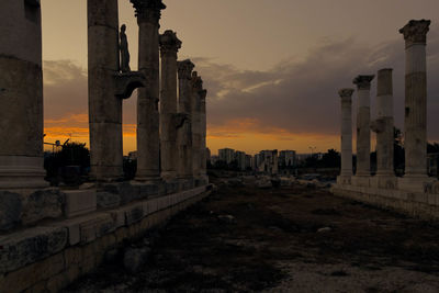Low angle view of old columns against cloudy sky at mezitli