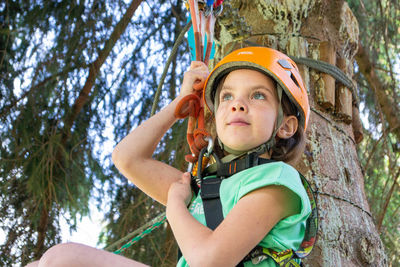 Adventure climbing high wire park - people on course in mountain helmet and safety equipment