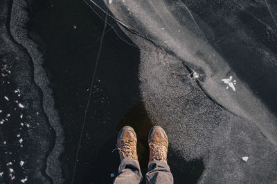 Low section of person standing on frozen lake