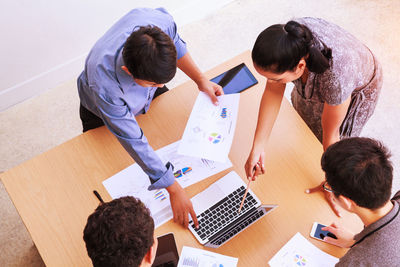 High angle view of people sitting on table