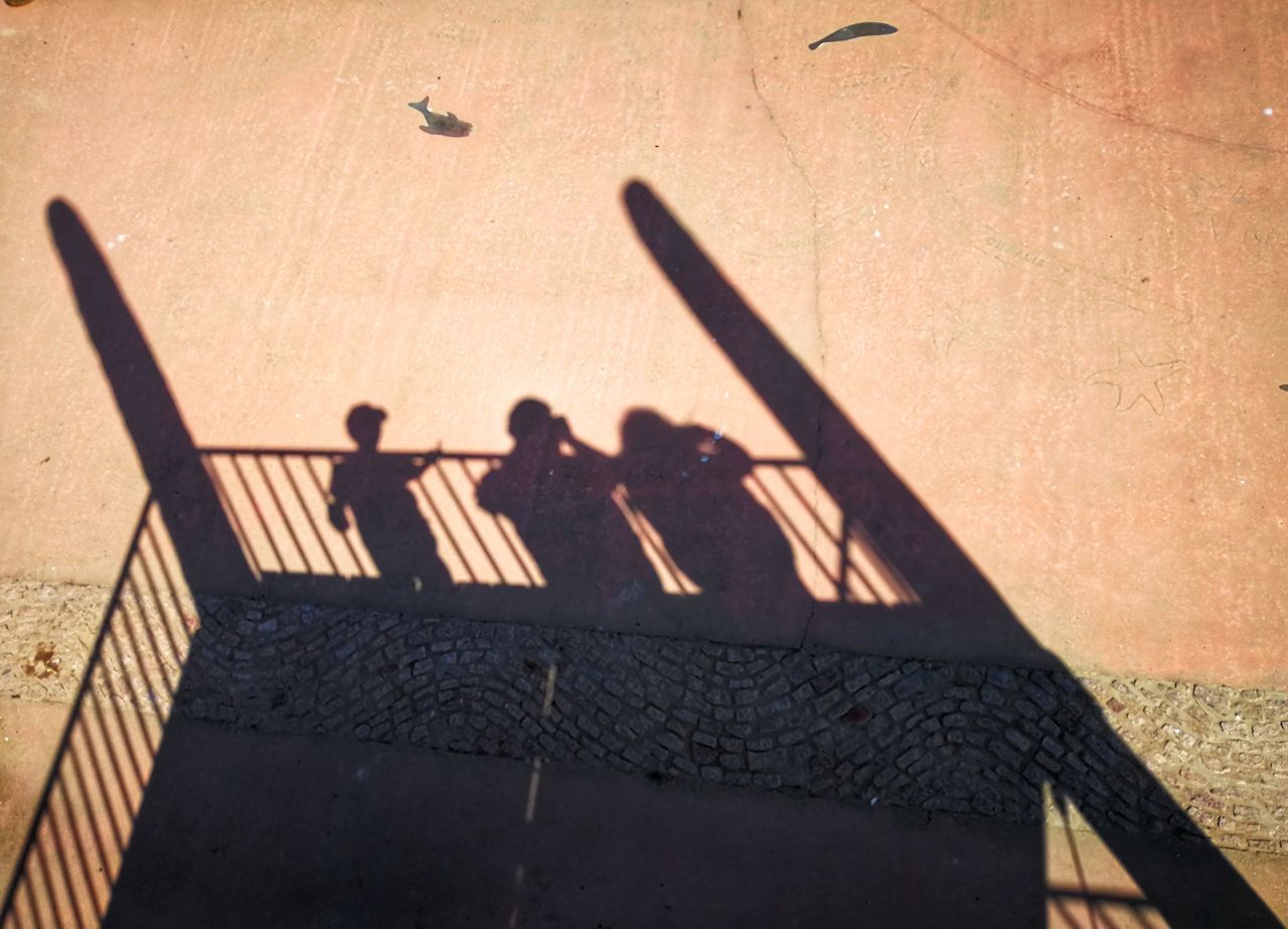 HIGH ANGLE VIEW OF PEOPLE STANDING ON WALL