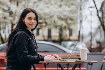 Portrait of young woman using mobile phone