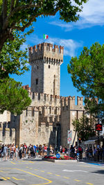 Group of people in front of historical building in sirmione - lake garda - italy