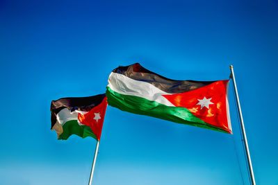 Low angle view of flag against blue sky