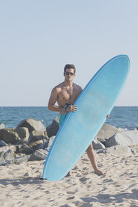 Portrait of shirtless man in sea against clear sky