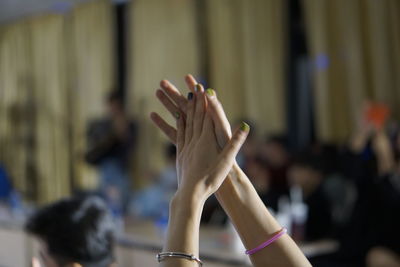 Close-up of hand holding hands against blurred background