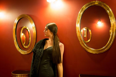 Woman standing by illuminated lighting equipment