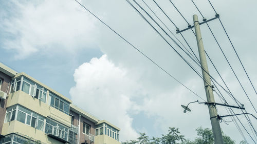 Low angle view of electricity pylon against sky