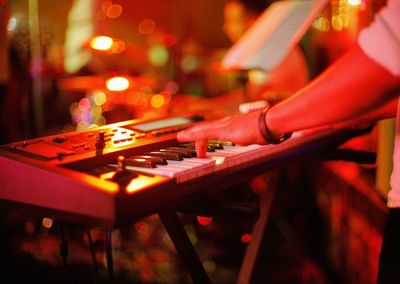 Close-up of man playing piano at night