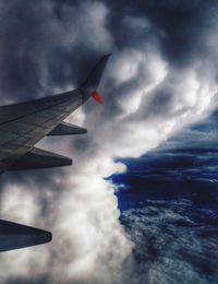 Cropped image of airplane flying over clouds