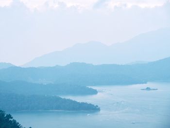 Scenic view of sea and mountains against sky