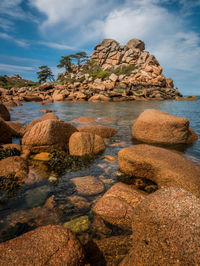 Rocks in sea against sky