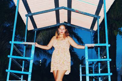 Portrait of young woman standing against the wall