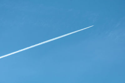 Low angle view of vapor trail against blue sky