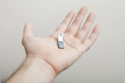 Close-up of hand holding hands over white background