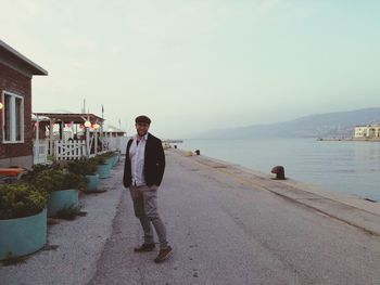 Man standing on sea shore against sky