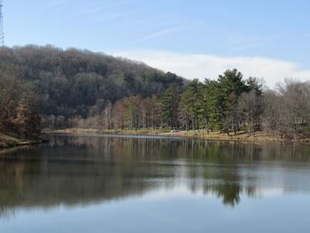 Scenic view of lake by trees against sky