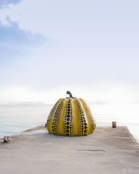 Yellow umbrella on beach against sky