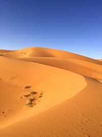 Scenic view of desert against clear blue sky