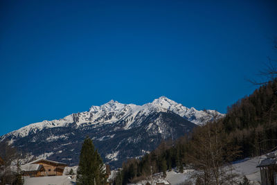 Scenic view of snowcapped mountains against clear blue sky