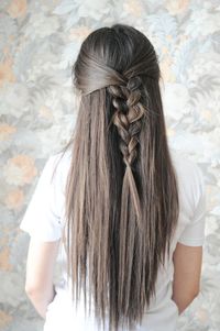 Rear view of woman with braided hair against wall