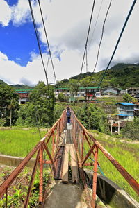 Bridge over canal amidst buildings in town against sky