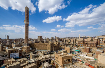 Buildings in city against cloudy sky