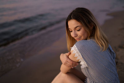 Midsection of woman holding while standing on beach